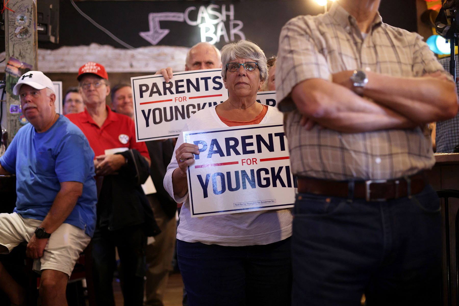 Voters listen as Glenn Youngkin speaks during a rally. Some participants hold signs that read "Parents for Youngkin."