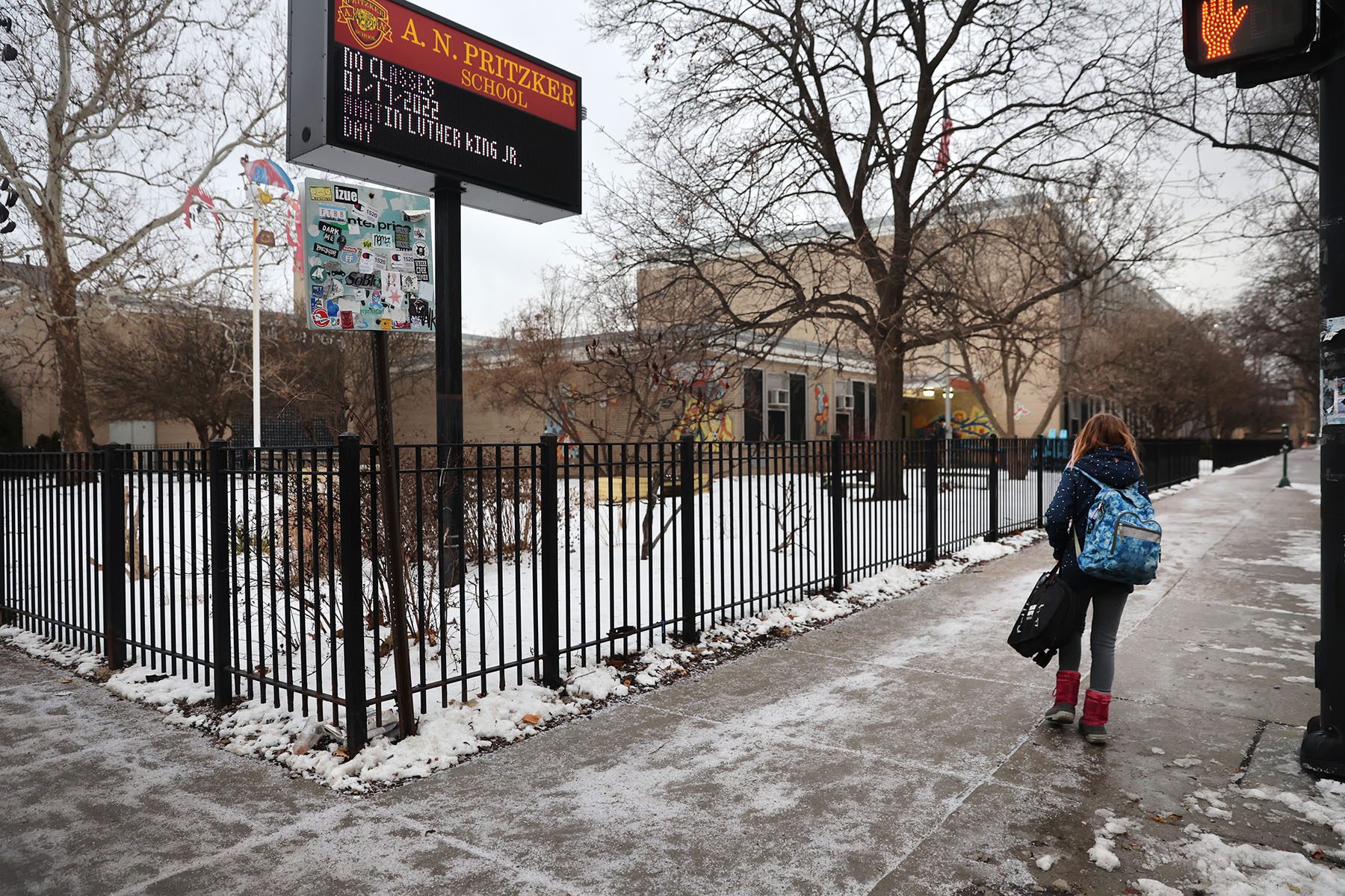 A student walks towards her school in the snow.
