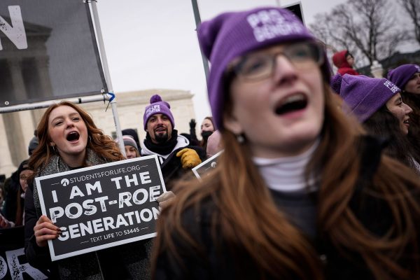 Anti-abortion activists rally outside the Supreme Court. One person holds a sign that reads 