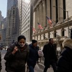 People walk past the New York Stock Exchange on a winter day.