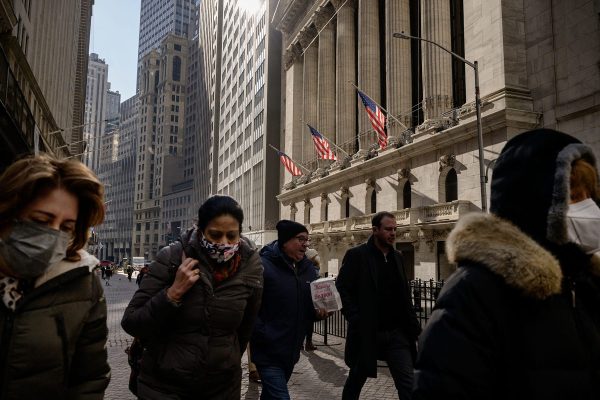 People walk past the New York Stock Exchange on a winter day.