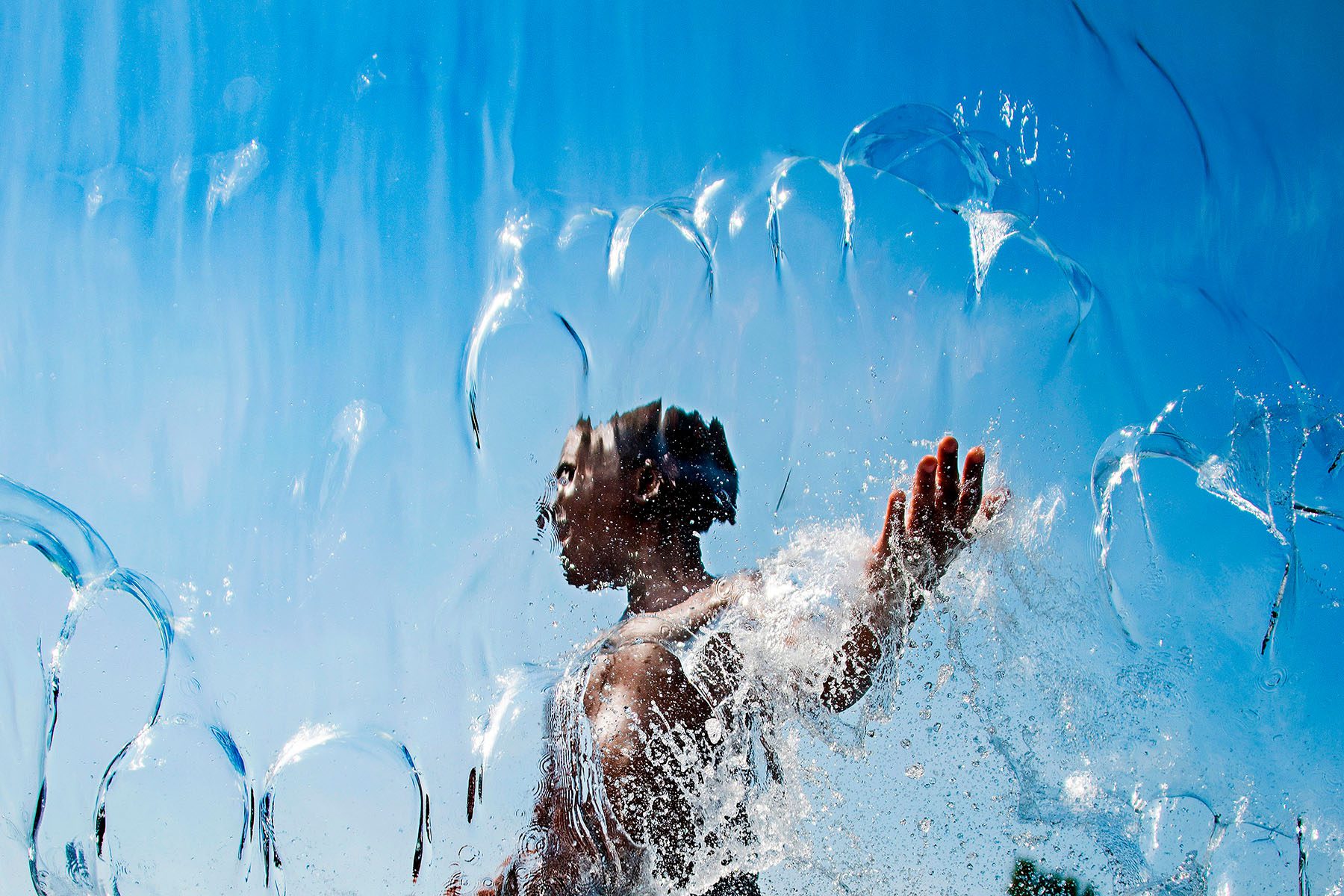 A child plays in a fountain.