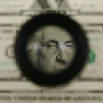 A magnifying glass is used to inspect newly printed one dollar bills at the Bureau of Engraving and Printing.