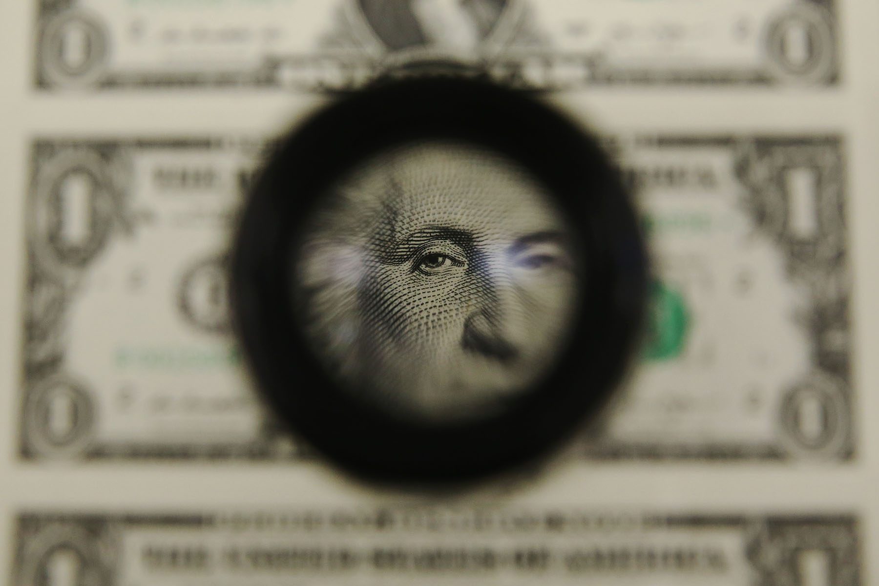 A magnifying glass is used to inspect newly printed one dollar bills at the Bureau of Engraving and Printing.