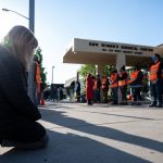 A demonstrator prostrates before a line of volunteer clinic escorts in front of the EMW Women's Surgical Center.
