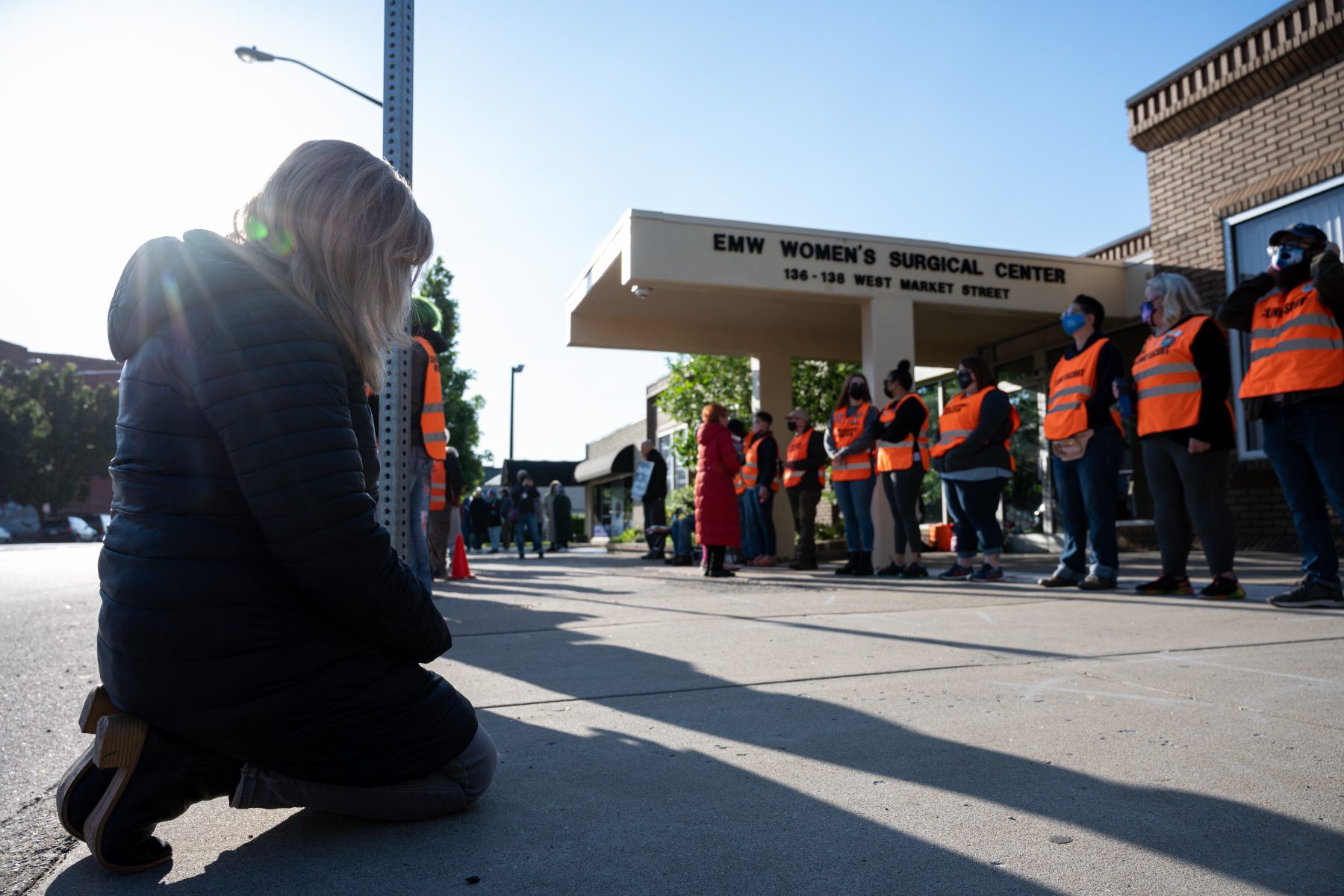 A demonstrator prostrates before a line of volunteer clinic escorts in front of the EMW Women's Surgical Center.
