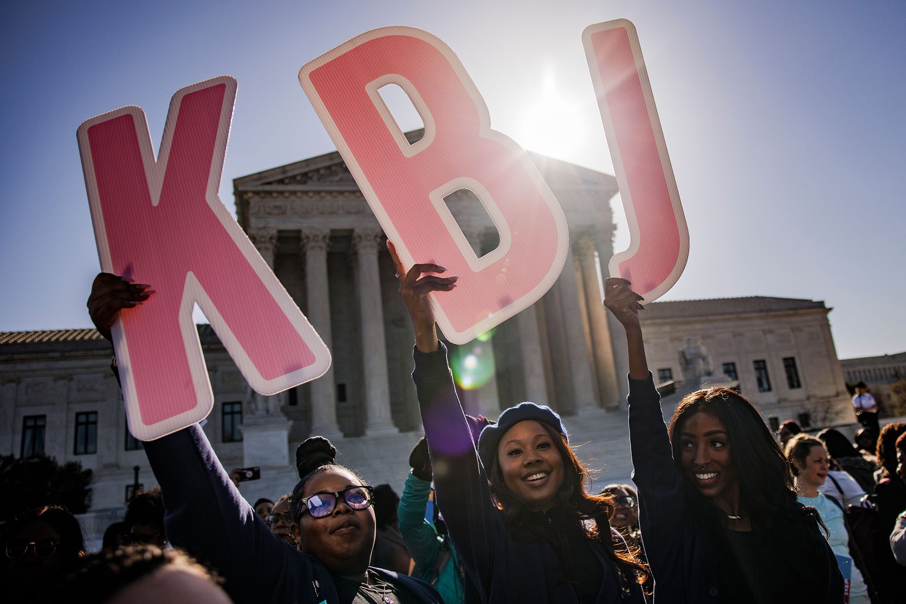 Women hold the letter "K," "B," and "J" at a rally in support of Ketanji Brown Jackson outside the Supreme Court.