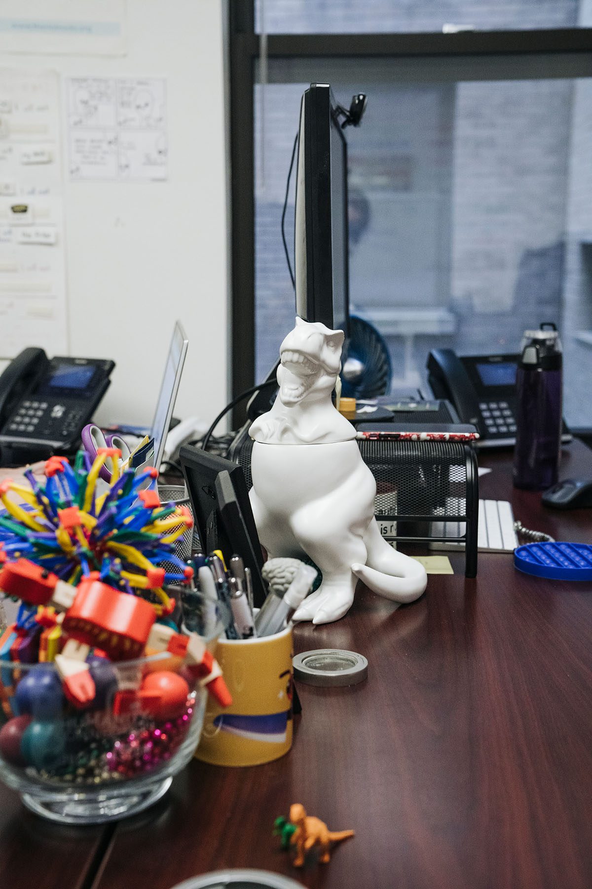 A white dinosaur cookie jar is seen on Julia Bascom's desk.