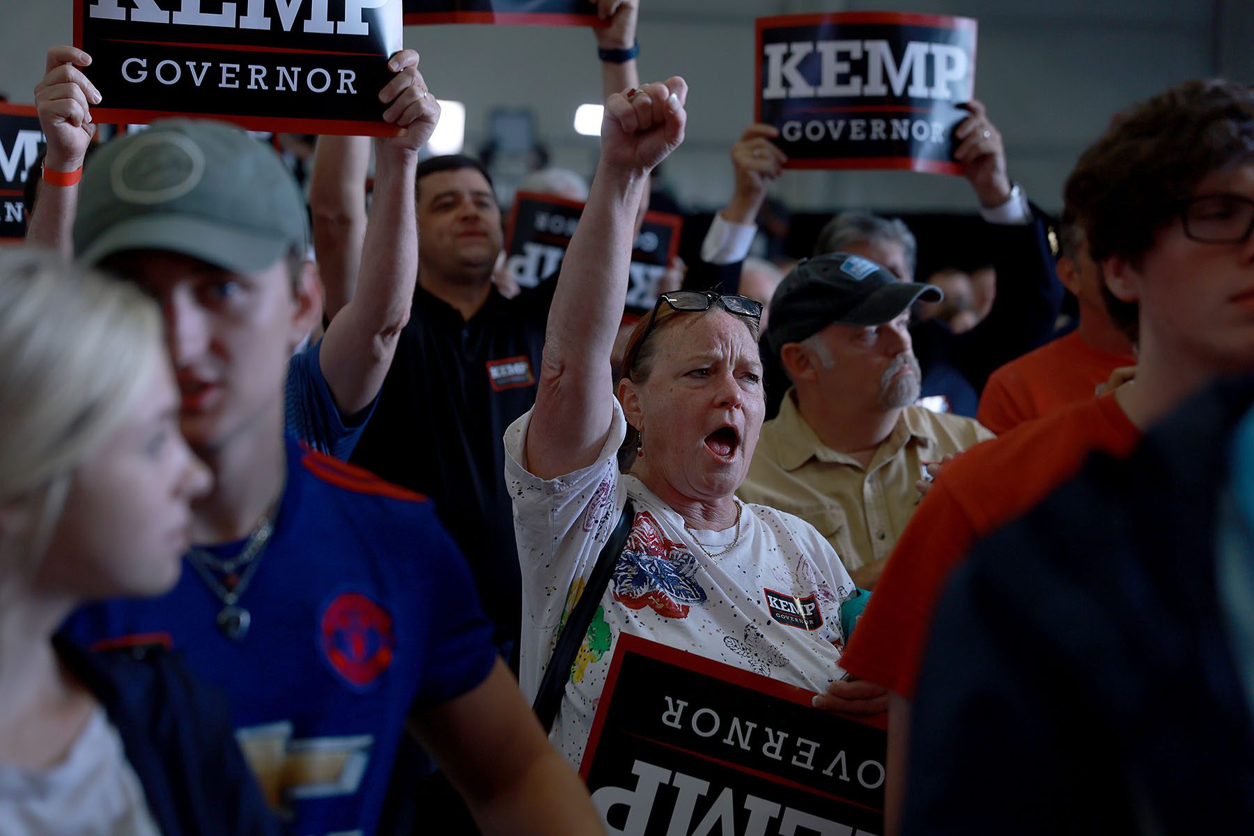 Attendees cheer and hold up signs that read "Kemp Governor."