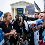 Abortion rights advocates and anti-abortions advocates face each other yelling in front of the U.S. Supreme Court.