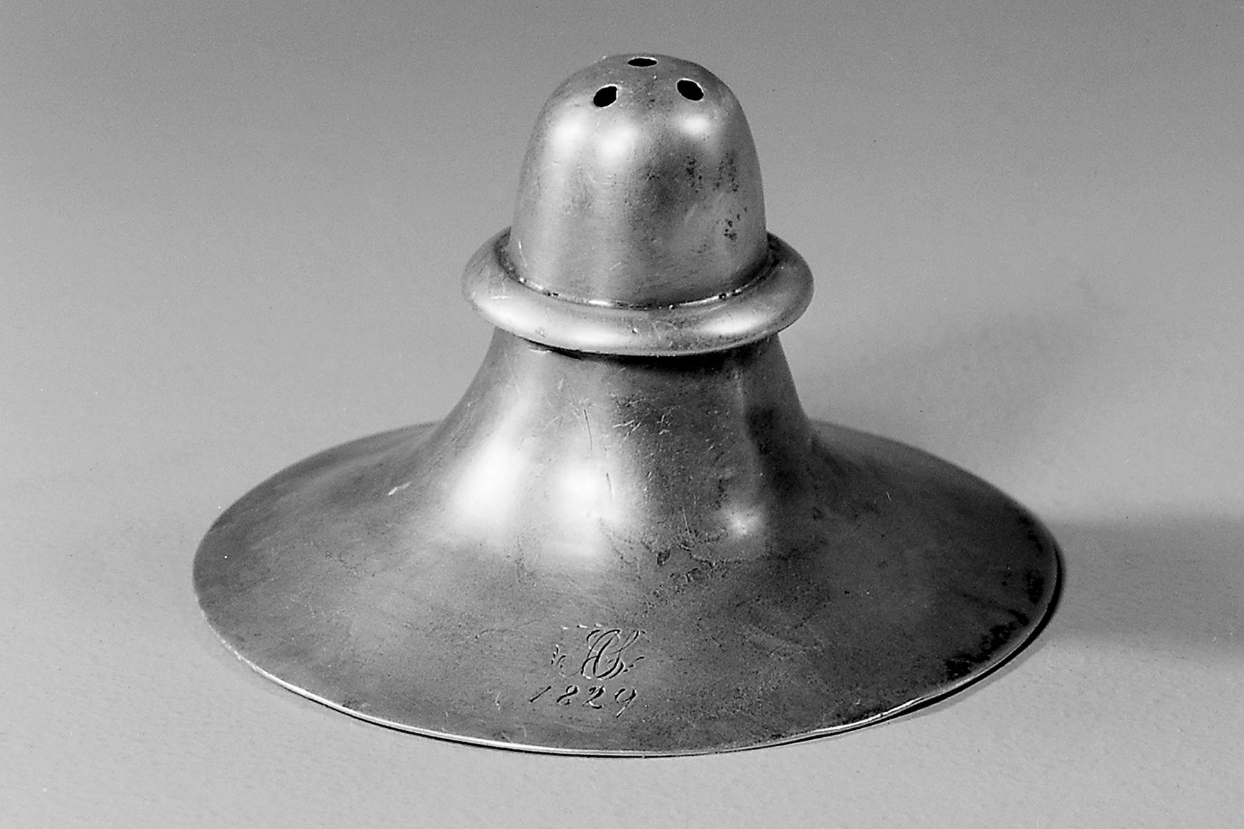 A silver nipple shield, engraved with the date 1829