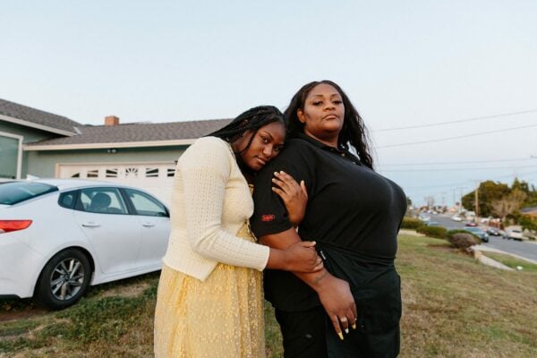 Ashley Manning is held by her daughter Rhiley after Ashley returns home from work. Ashley is wearing her work uniform.