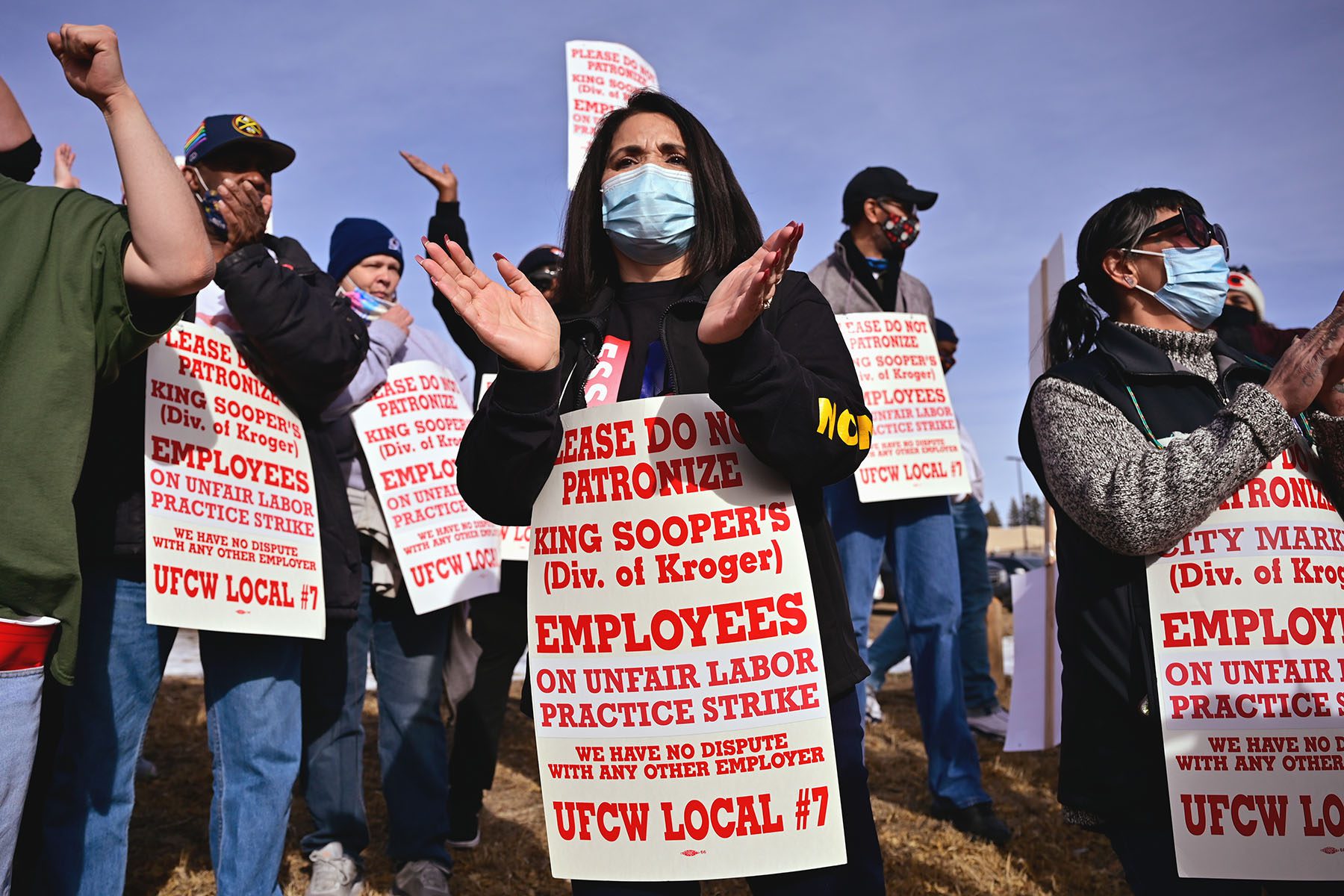 Kim Cordova leads a rally. She is surrounded by striking employees holding signs that read "Please do not patronize King Sooper's. Emplyees on unfair labor practice strike. we have no dispute with any other employer."