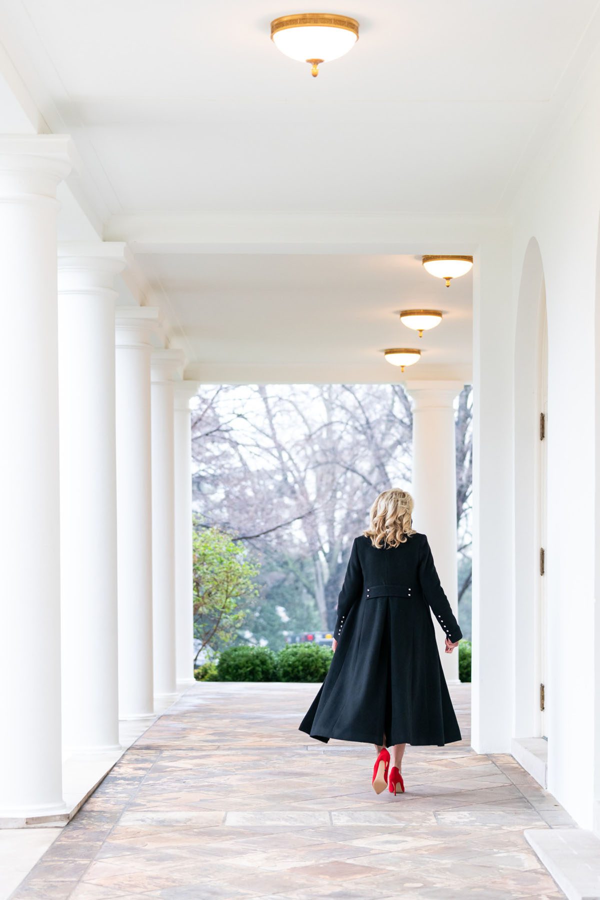 Jill Biden walks along the Colonnade of the White House.