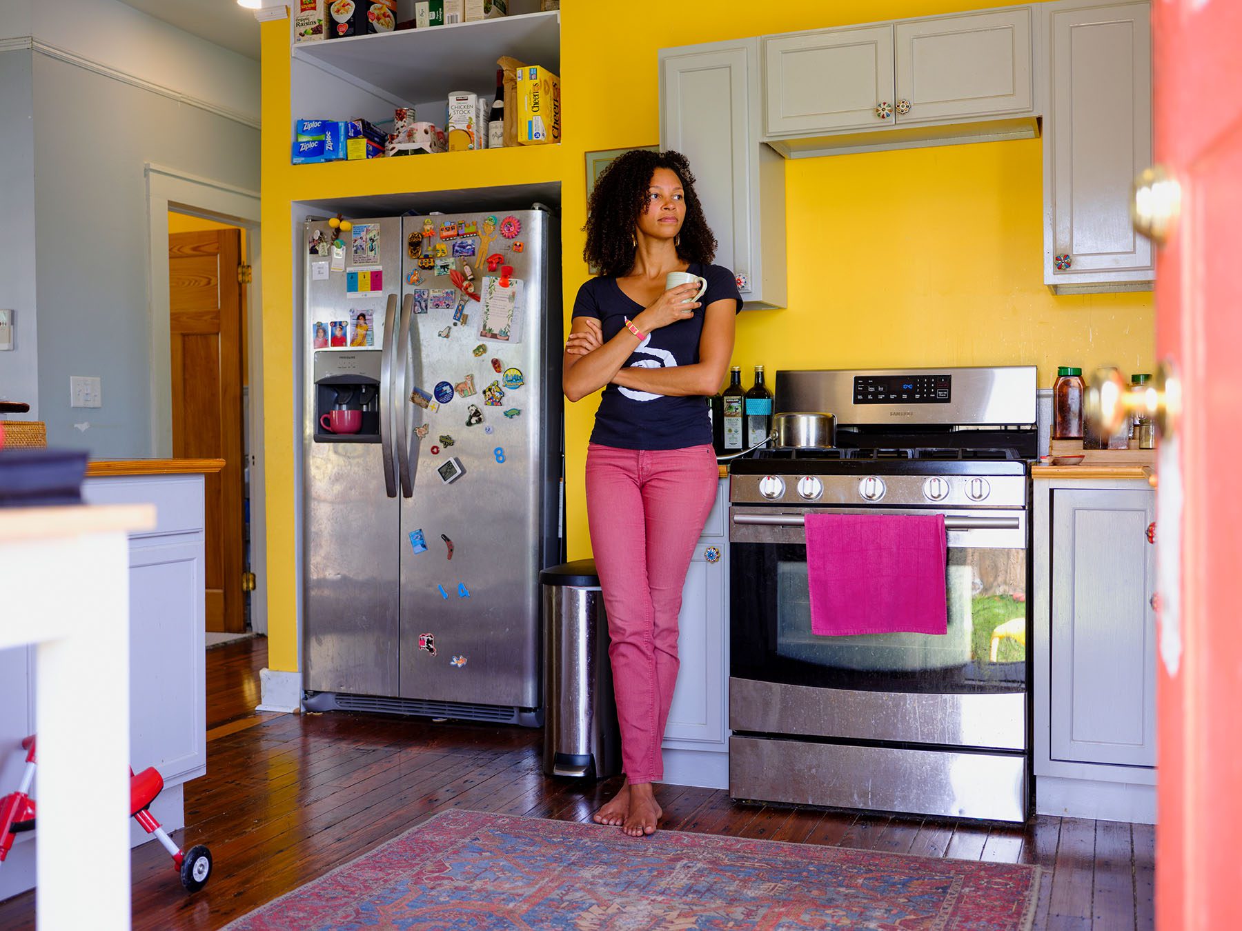 Malaika Ludman holds a mug in her kitchen as she poses for a portrait.