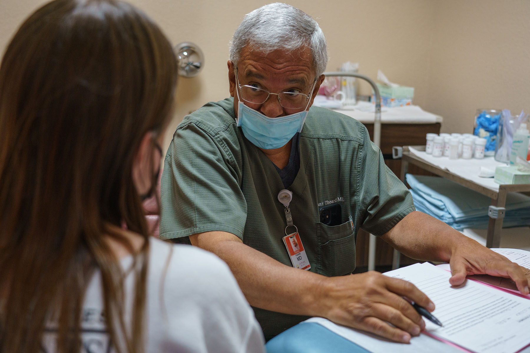 A doctor wearing a face mask speaks with a woman seeking an abortion.
