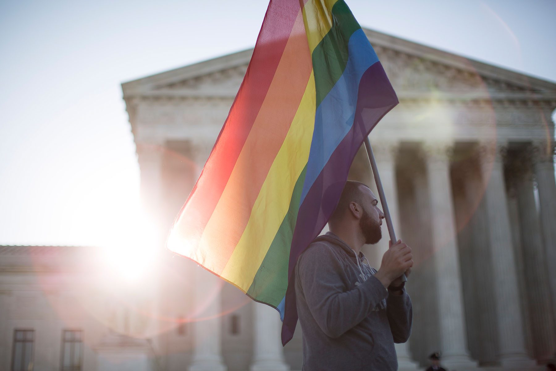 A supporter of same-sex marriage holds a pride flag near the Supreme Court.