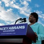 Stacey Abrams speaks from a podium during a campaign rally.
