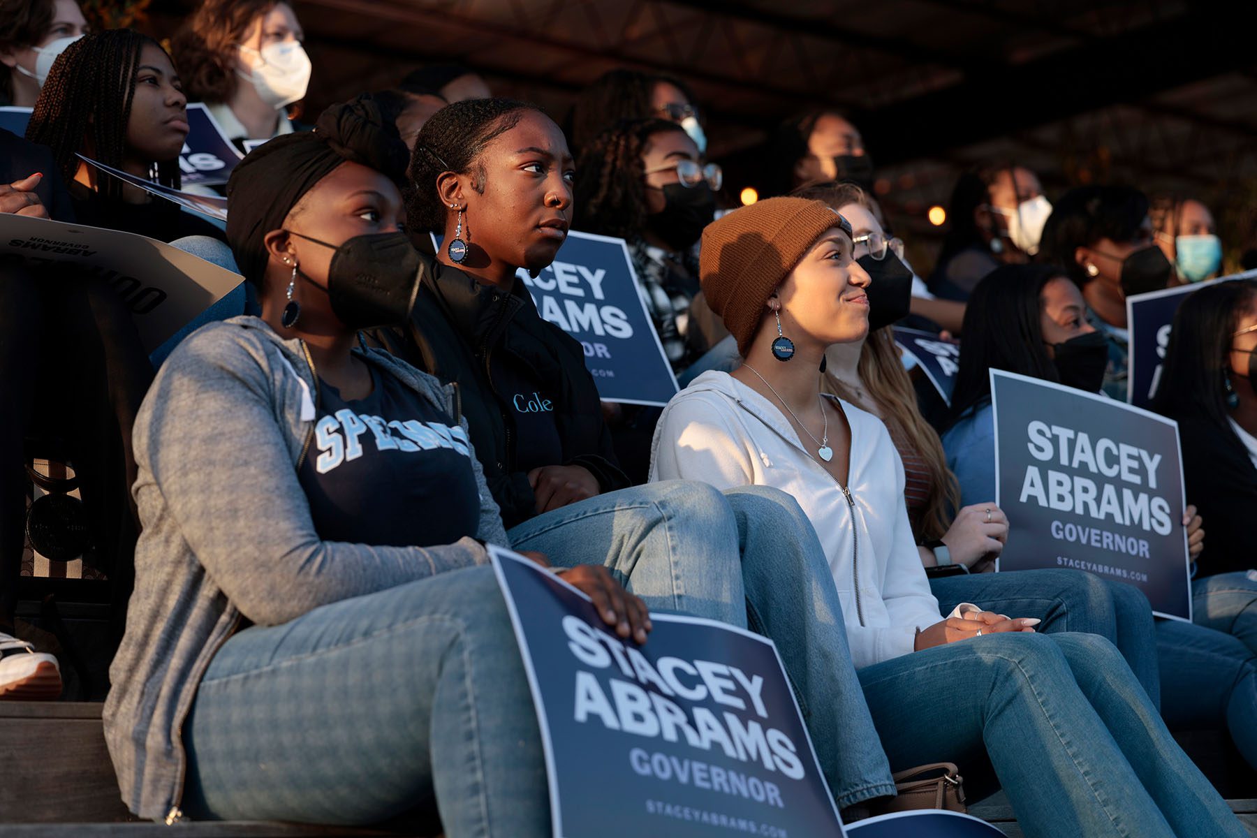 Supporters listen and hold signs in support of Stacey Abrams during a campaign rally.