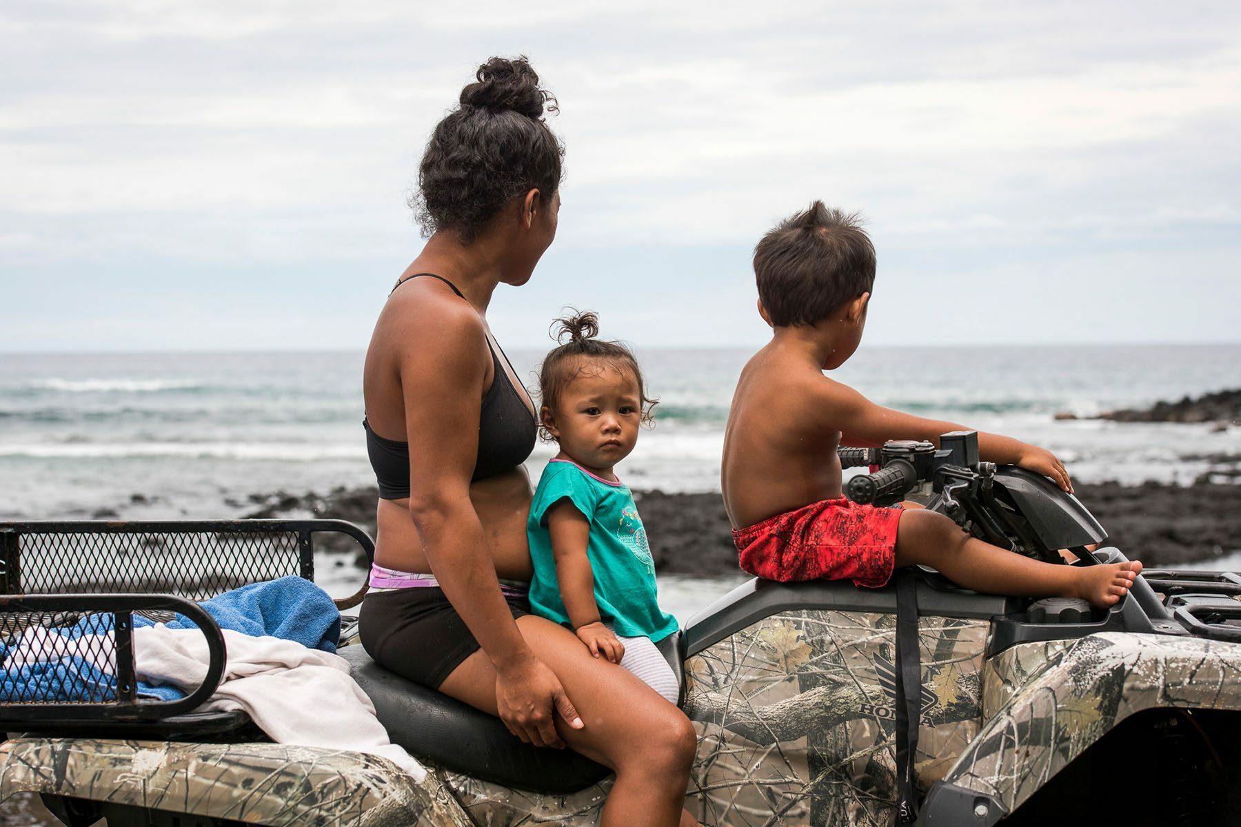 Shanelle Casuga and her children watch the coast on an ATV before the arrival of a hurricane.