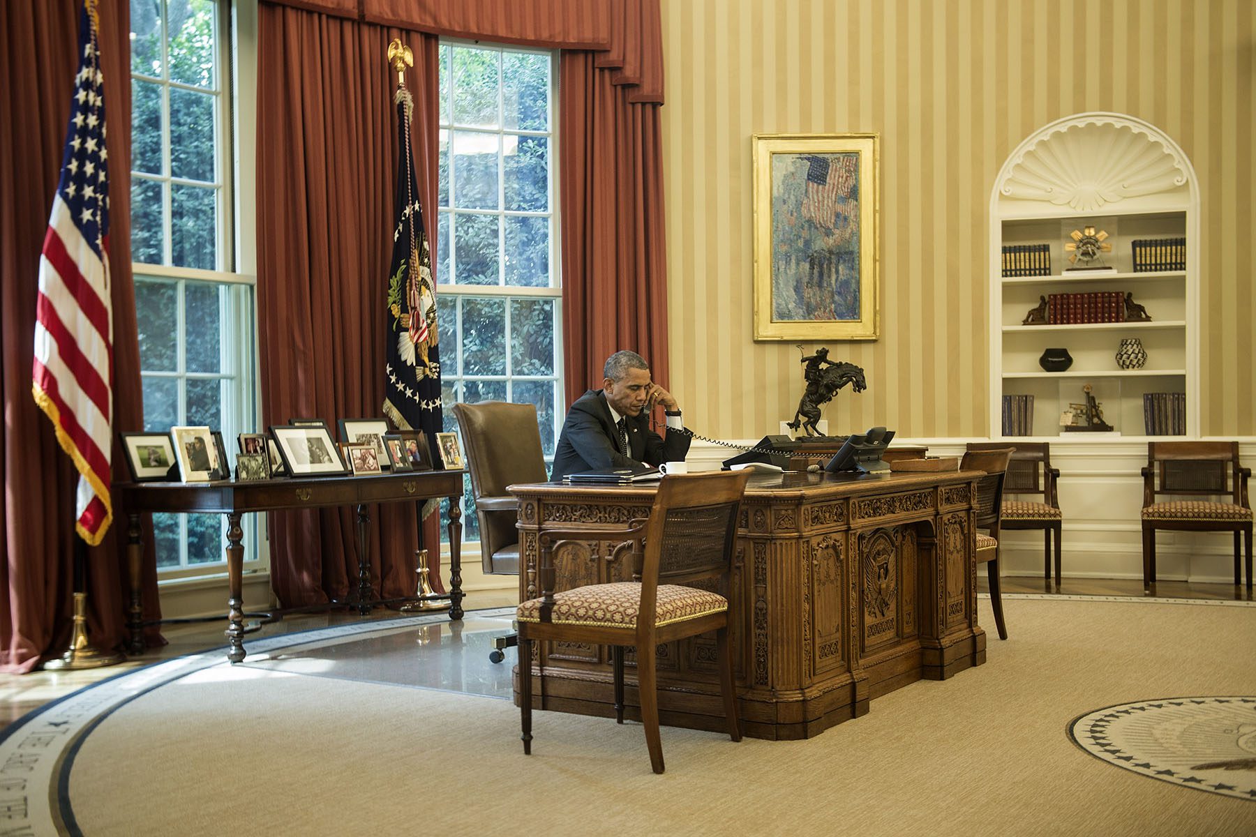 President Obama speaks on the phone in the Oval Office.