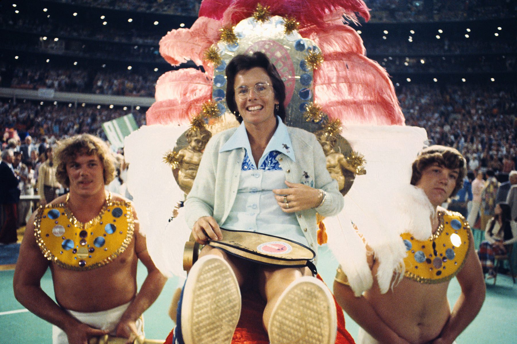 Tennis star Billie Jean King is carried to the court by four men for the battle of the sexes tennis match.