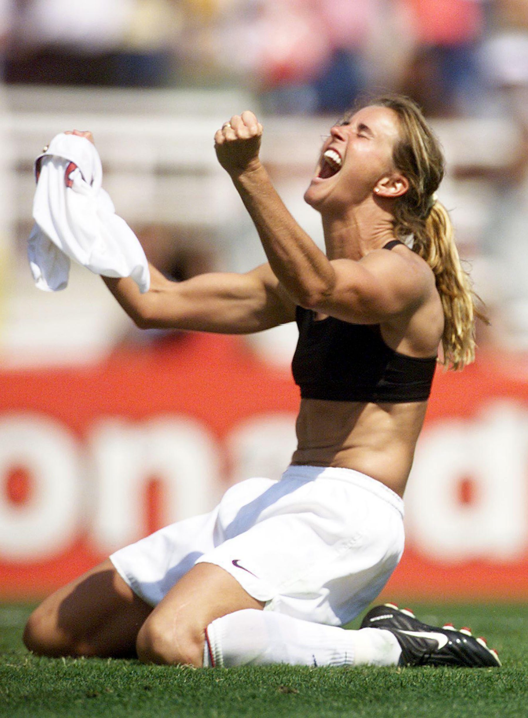 Brandi Chastain celebrates hitting the winning penalty kick against China in the World Cup final by waving her jersey in the air.