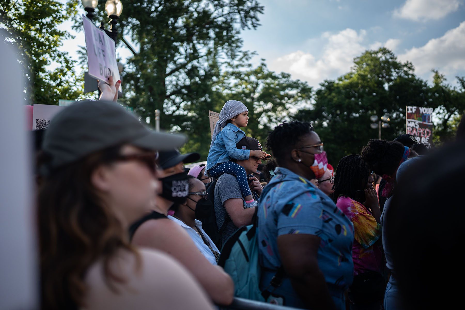 A child is seen on their parents' shoulders as Abortion rights demonstrators gather outside the U.S. Supreme Court.
