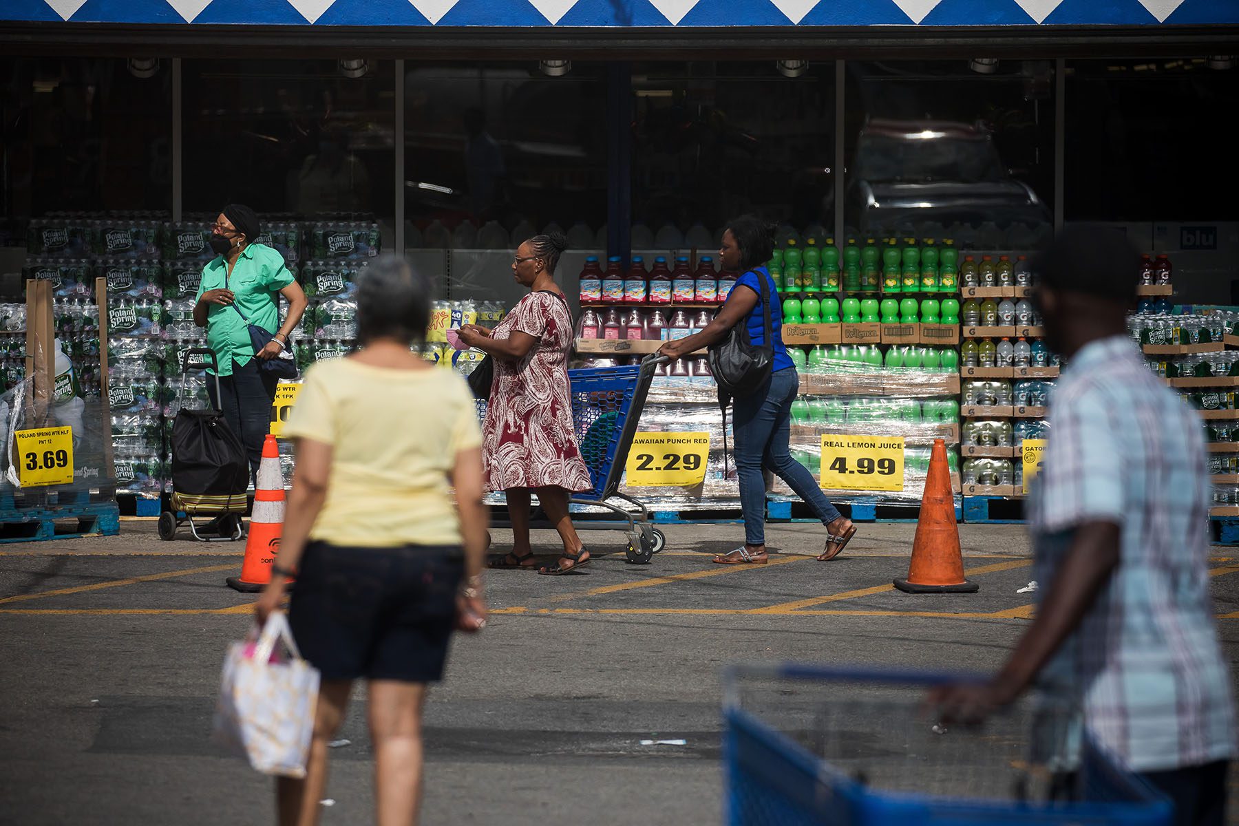 People push carts in the parking lot of a grocery store.