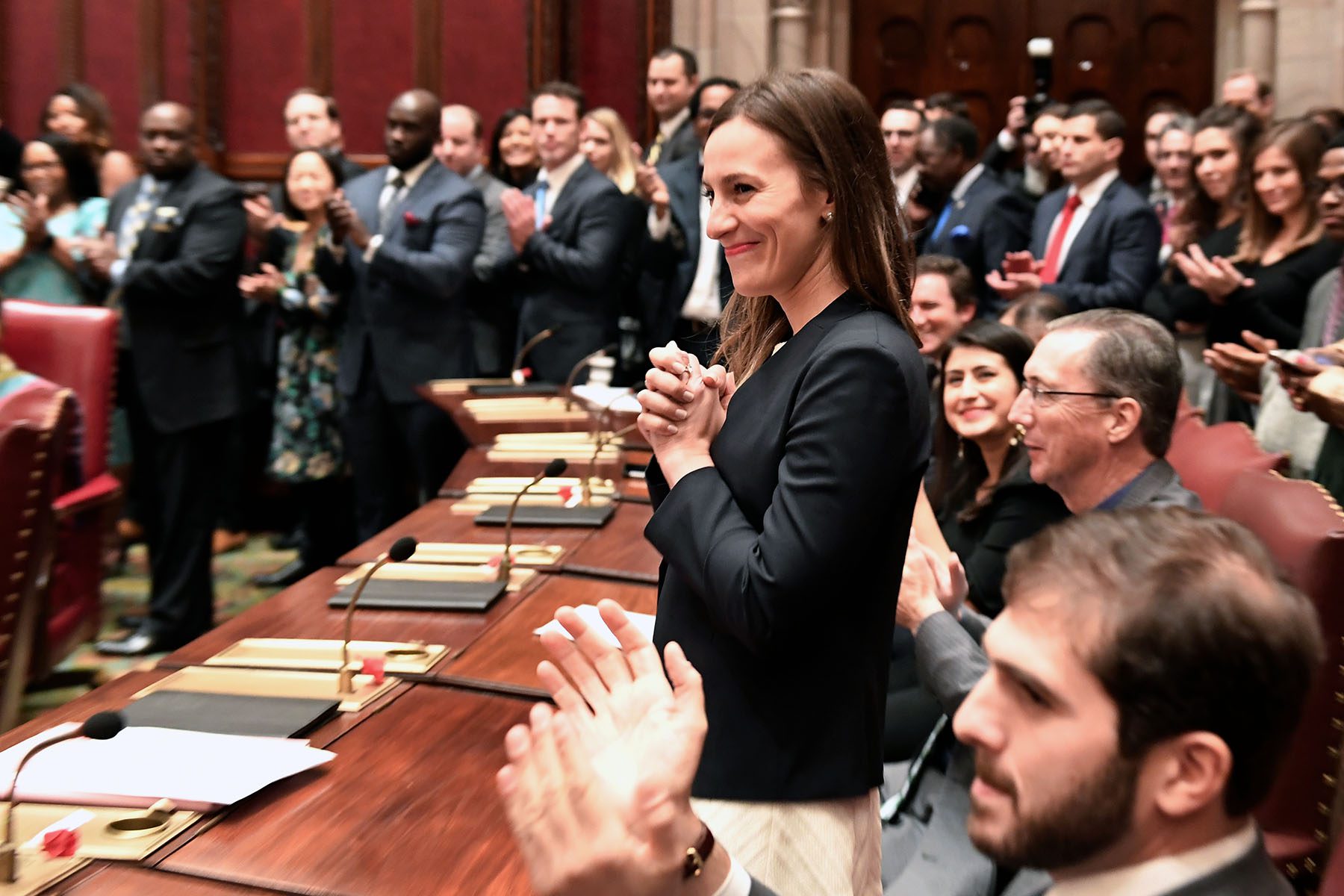 Sen. Alessandra Biaggi smiles as other elected officials clap.