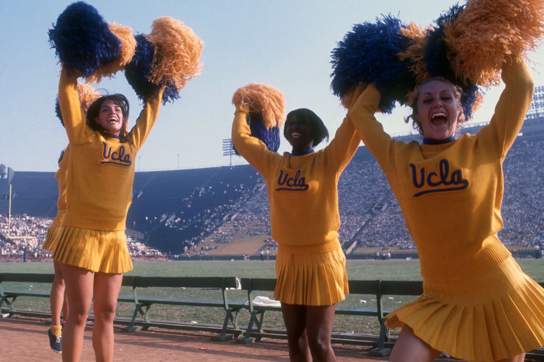 Cheerleaders for the University of California Los Angeles Bruins celebrate by waving their pompoms.