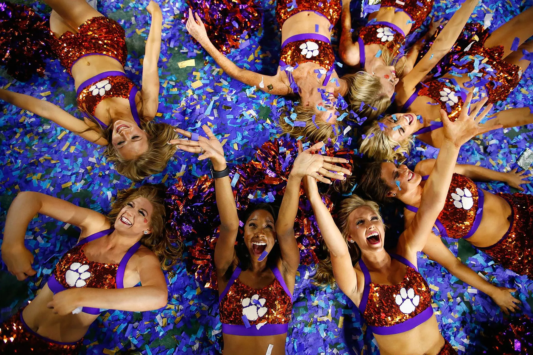 Clemson Tigers cheerleaders play in confetti at the end of a game.