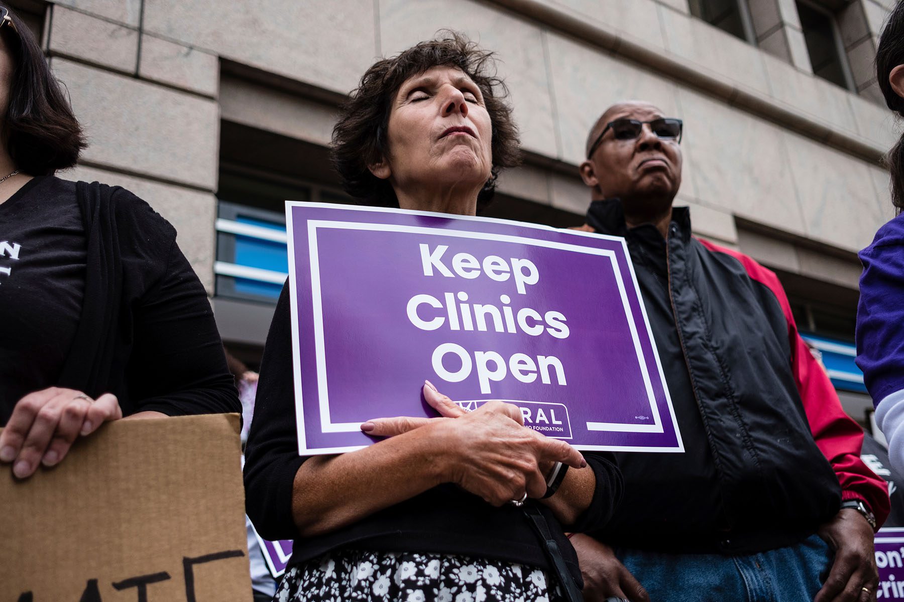 An activist seen holding a placard that says keep clinics open during a protest.
