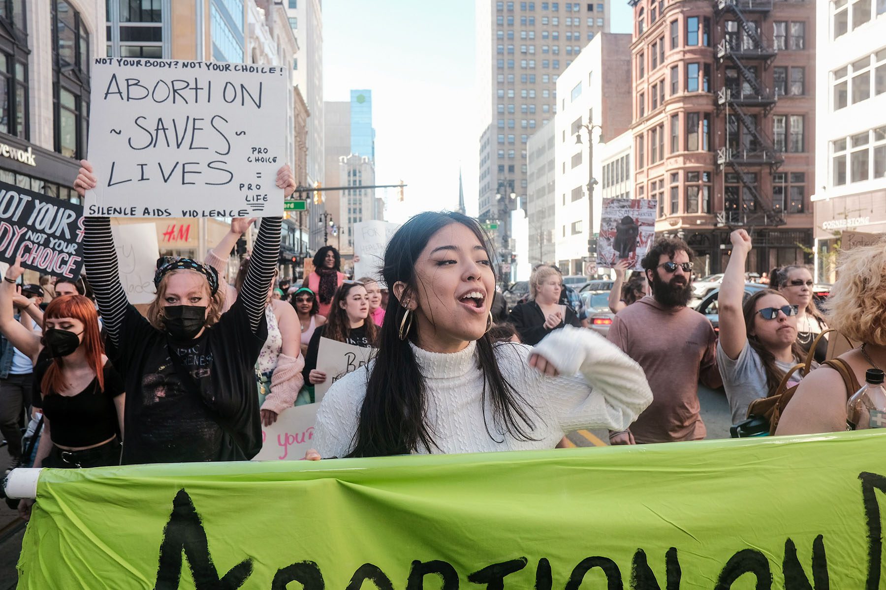 Protesters hold placards, chant, and march through downtown Detroit.