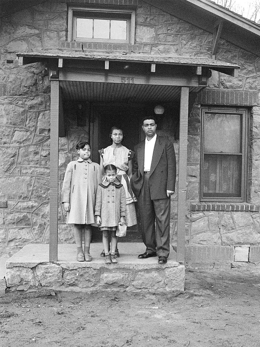 An image of a family standing on the front porch of their home.