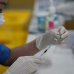 A health worker prepares covid-19 vaccine for young children
