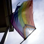 A pride flag is displayed outside a home