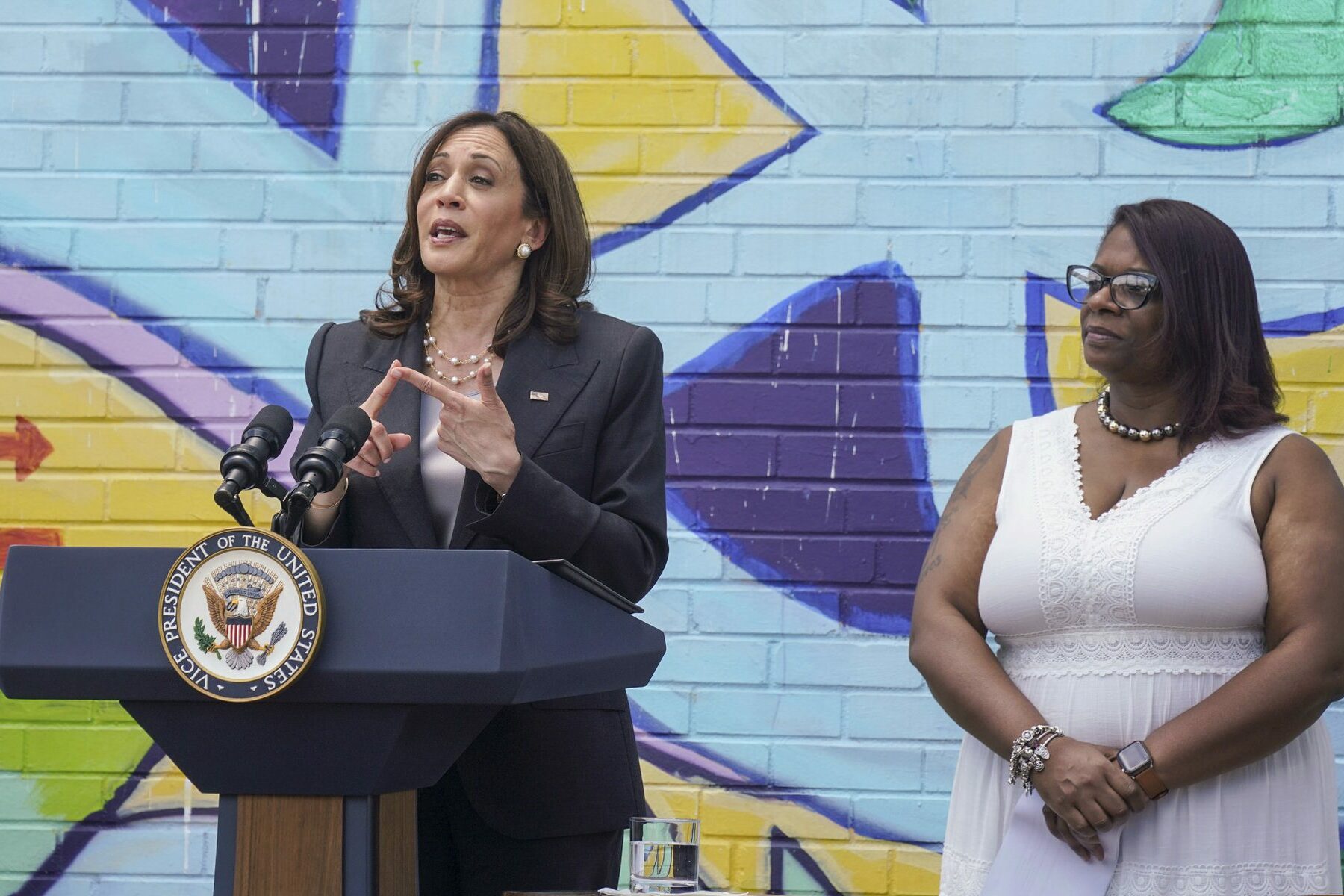 Kamala Harris talks in front of a colorful mural; assistant Pittsburgh city clerk Kimberly Clark-Baskin stands to her side