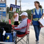 Cathy Nix is seen walking and holding a clipboard outside Planned Parenthood. A couple other anti-abortion protesters sit near the clinic.