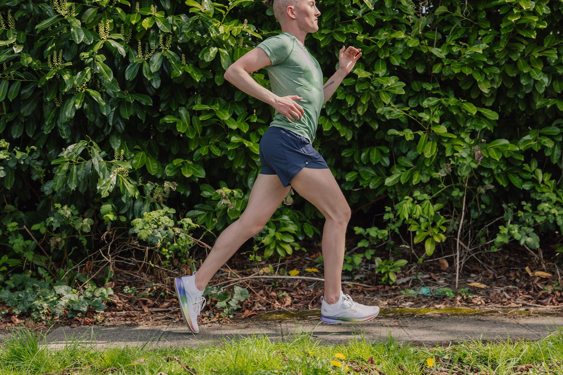 Jake Fedorowski, a nonbinary runner in green shirt and blue shorts