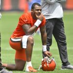 Cleveland Browns quarterback Deshaun Watson kneels on a football field.