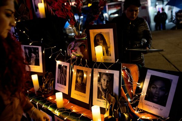 A community group holds a memorial vigil on Transgender Day of Remembrance. Pictures of the victims are displayed on a candlelit alter with their names and ages.