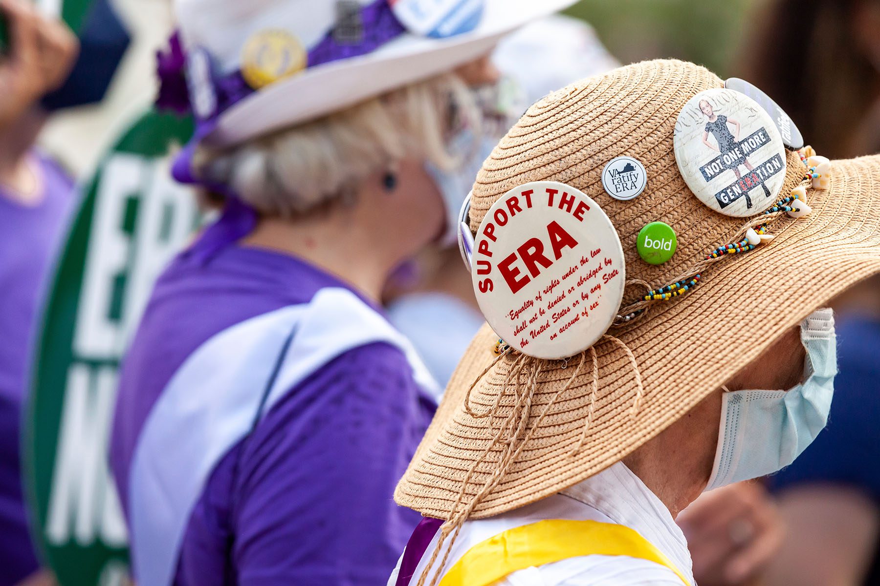 Demonstrators dressed in suffragette outfits rally near the Supreme Court. Pins on one woman's hat read "Support the ERA," "VA ratify ERA" and "No one more generation"