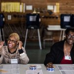 Two poll workers share a laugh with voters during the 2016 primaries in South Carolina.