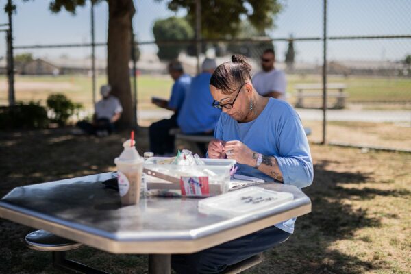 Jolina Olivia Diaz, a transgender female inmate, makes jewelry in the yard of a men's prison in California.