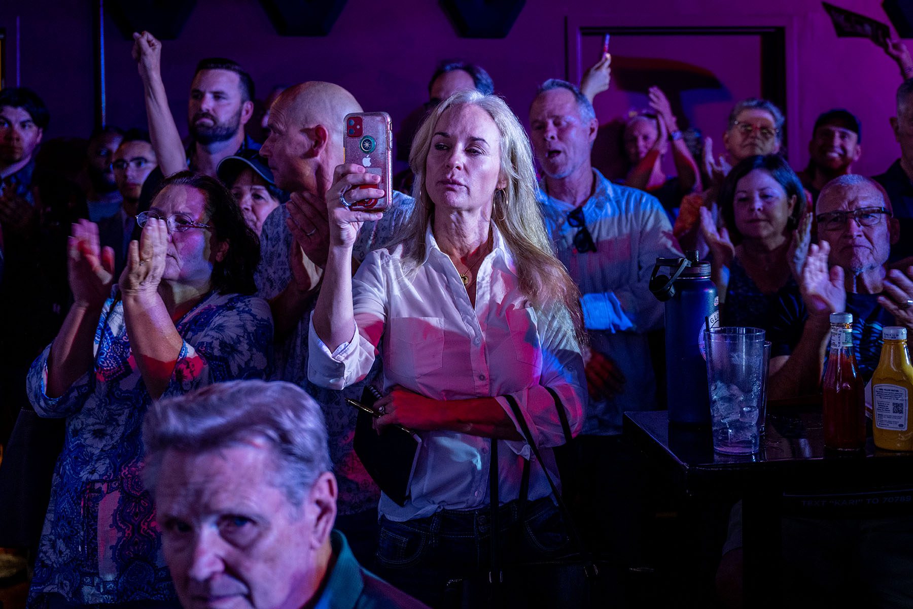 A woman takes a picture with her cellphone during a campaign event for GOP candidates at a restaurant.
