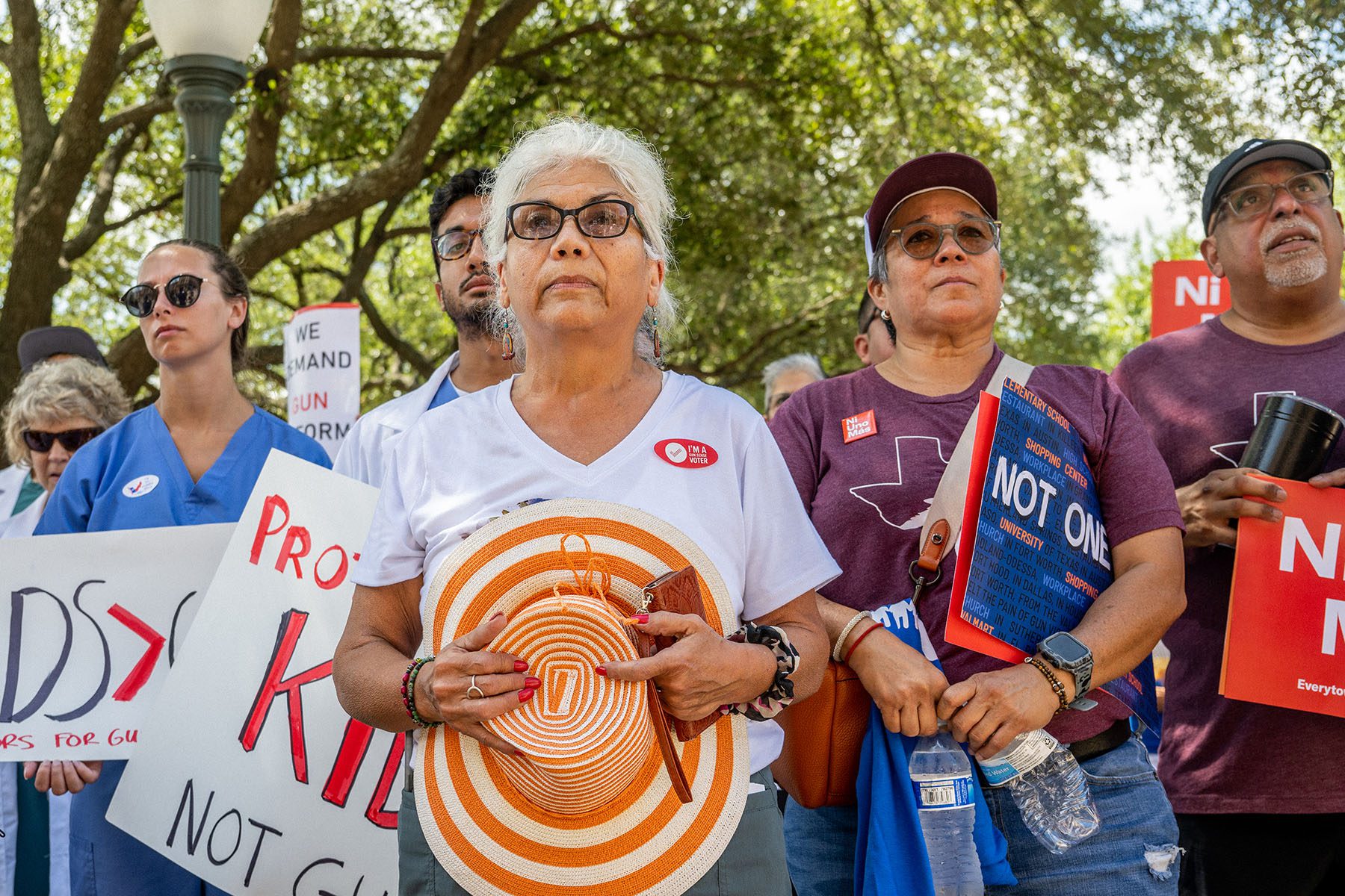 People hold signs as they rally against gun violence.