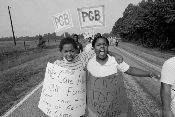 Two young girls wear protest signs that read 