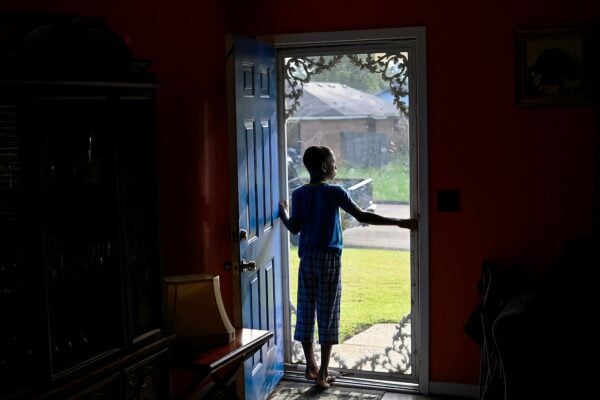 A boy peers out of his front door in Jackson, Mississippi.