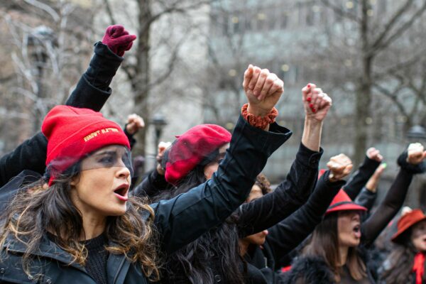 Women protest and sing songs with their fists in the air as Harvey Weinstein attends a pretrial session in New York City.